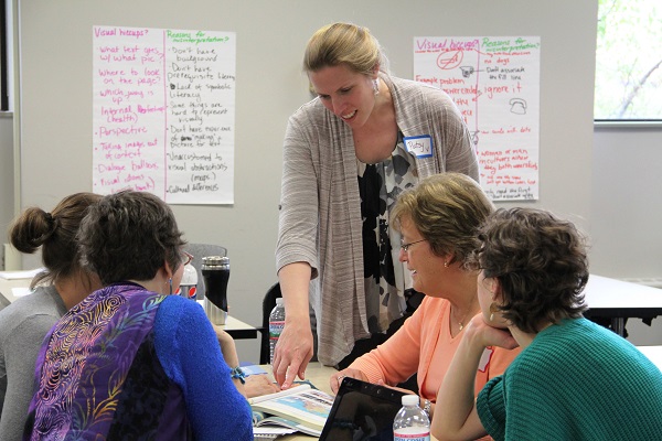 Adult Education staff sit around a table at an educator training event